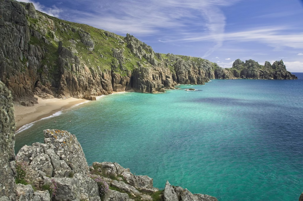 Turquoise water and pale sand at Pedn Vounder beach below the granite cliffs at Porthcurno in west Cornwall